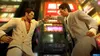 Two men in suits are in a street scene with neon lights. Produktbild-Vorschau