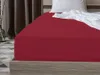 A close-up view of a red fitted sheet on a bed, with a white pillow and crumpled white sheet visible at the top. Produktbild-Vorschau
