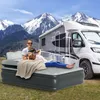 A person and a dog relaxing on an inflatable mattress next to a camper van with mountains in the background. Produktbild-Vorschau