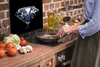 A person is cooking in a kitchen with a glass splashback showing a diamond. Náhľad obrázku produktu