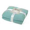 A folded teal blanket with a tag and ribbon. Produktbild-Vorschau