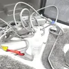 A close-up view of various accessories and cables for a cleaning device, including a bottle of cleaning solution and some fabric pads. Produktbild-Vorschau