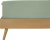 A close-up side view of a bed with a light green fitted sheet on a wooden bed frame. Produktbild-Vorschau