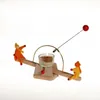 A wooden seesaw-like candle holder with two small figures and a lit candle. Anteprima dell’immagine prodotto