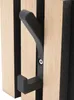 A close-up shot of a black hook attached to a wooden panel with black stripes. Produktbild-Vorschau