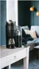 A black Melitta coffee maker sits on a white table in a living room setting. Náhľad obrázku produktu