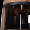 A close-up view of a wooden barrel-shaped wine rack with several wine bottles inside. Náhled obrázku produktu