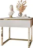 A white nightstand with gold accents, featuring a bust, a vase with dried flowers, and a jar on top. Produktbild-Vorschau