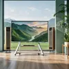 A modern living room with a large TV on a stand, flanked by speakers, with a large window showing a mountain landscape. Podgląd zdjęcia produktu