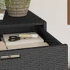 A close-up view of a black poly rattan storage cabinet with books and scissors inside. Náhľad obrázku produktu