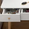 A close-up view of a white vanity table with open drawers filled with makeup and a hairbrush on top. Podgląd zdjęcia produktu