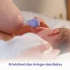 A close-up of a mother using a breast pump on her nipple while holding her baby. Náhled obrázku produktu