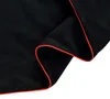 A close-up view of black fabric with a red trim. Náhľad obrázku produktu