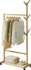A wooden garment rack with clothes hanging on it, a storage bag, and shoes on the bottom shelf. Produktbild-Vorschau