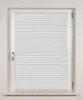 A white pleated blind is shown in a white window frame against a white wall. Produktbild-Vorschau