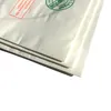 A close-up view of stacked white paper bags, with some text and a green circular logo visible on the top bag. Produktbild-Vorschau