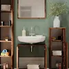 A bathroom vanity with a sink, mirror, and shelving units. The vanity is made of rustic wood and has a dark green front panel. Towels and toiletries are neatly arranged on the shelves. Produktbild-Vorschau
