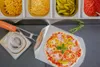 A prepared pizza is being held on a pizza peel, with various toppings in stainless steel containers in the background. A sprig of rosemary is placed next to the pizza. Produktbild-Vorschau