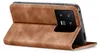 A brown flip case for a smartphone is shown from the side, with the phone inserted and its camera module visible. Produktbild-Vorschau