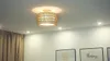 A rattan ceiling light fixture is shown in a room with white walls and curtains. Produktbild-Vorschau