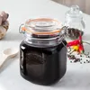 A Kilner preserving jar filled with a dark liquid, placed on a marble countertop with ingredients like garlic, chili peppers, and peppercorns in the background. Anteprima dell’immagine prodotto
