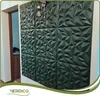 A wall decorated with dark green 3D wall panels, with a light fixture above. Podgląd zdjęcia produktu