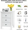 A white bedside table with three drawers is shown, with various decorative and functional items displayed around it in circular frames, illustrating its storage capacity and potential uses. Podgląd zdjęcia produktu