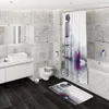 A modern bathroom with marble-tiled walls, dark wood flooring, a white vanity with a vessel sink, a toilet, and a bathtub with a shower curtain featuring a zen stone and lotus flower design. Produktbild-Vorschau