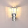 A modern outdoor wall lamp with a motion sensor is mounted on a light gray wall. Produktbild-Vorschau