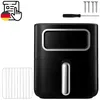 A black air fryer with a silver handle and a silver trim around the viewing window, shown on a white background. Accessories like screws, a screwdriver, and a wire rack are also visible. Produktbild-Vorschau