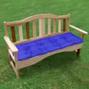 A blue cushion on a wooden garden bench outdoors on grass. Produktbild-Vorschau