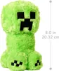 A plush toy of a Minecraft Creeper character, with a ruler indicating its size. Produktbild-Vorschau