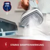 A person is holding a steam iron, demonstrating its steam output. Podgląd zdjęcia produktu