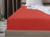 A close-up view of a red fitted sheet on a bed. Náhled obrázku produktu