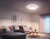 A modern living room with a sofa, coffee table, and a ceiling light. Produktbild-Vorschau