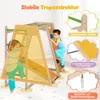 Two children are playing on a wooden indoor climbing frame with a slide and other accessories. Podgląd zdjęcia produktu
