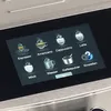 A close-up view of a digital display on a coffee machine, showing various drink options. Produktbild-Vorschau