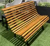 A wooden slatted bench on a green artificial grass surface. Produktbild-Vorschau