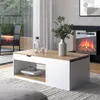 A modern living room with a coffee table in the foreground, featuring an electric fireplace and outdoor view in the background. Voir les images du produit