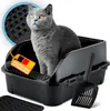 A gray cat sits in a black litter box with a scoop and a mat nearby. A tag with the German flag and text is attached to the litter box. Produktbild-Vorschau