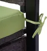 A close-up view of a green cushion tied to a black metal frame with a light green tie. Podgląd zdjęcia produktu