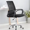 A black office chair is shown in a room with a desk and some flowers. Produktbild-Vorschau
