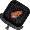 A steak is placed in the basket of an air fryer. Produktbild-Vorschau