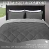A bed with a gray comforter and pillows, with text overlays describing the product. Produktbild-Vorschau