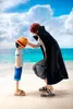 Two anime figurines, Shanks and Monkey D. Luffy as a child, on a beach with the ocean and sky in the background. Náhled obrázku produktu
