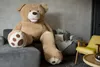 A large teddy bear is sitting on a sofa in a living room. Anteprima dell’immagine prodotto
