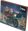 Santa Claus riding a motorcycle with a sack of gifts through a snowy village at night. Podgląd zdjęcia produktu