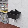 A black sink with a faucet is mounted on a concrete wall in a garage or workshop setting. Storage bins and tools are visible in the background. Produktbild-Vorschau