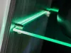 A close-up view of a glass shelf with green LED lighting in a display cabinet. Produktbild-Vorschau