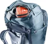 A close-up view of the top compartment of a backpack, showing a first aid kit and some clothing. Podgląd zdjęcia produktu